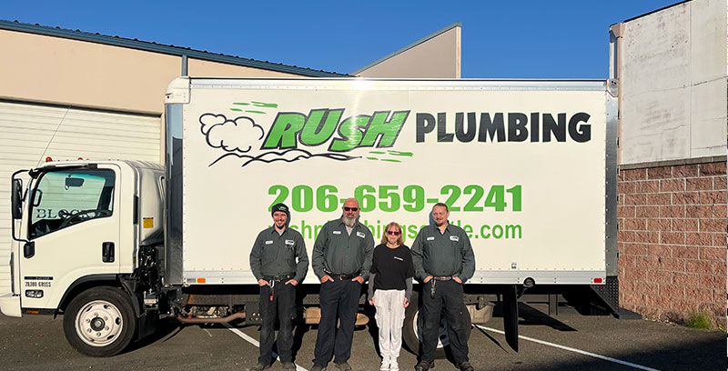 4 plumbers from Rush Plumbing standing in front of a Rush Plumbing truck before leaving for a plumbing service call to Ballard