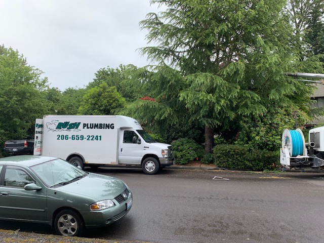 Rush Plumbing truck parked at curb of home on street while the workman not seen in photo are working on the irrigation system