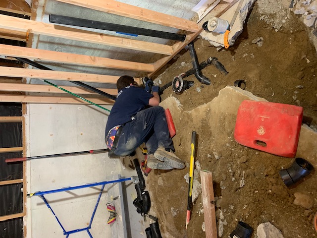 Rush Plumbing serviceman working on replacing piping due to high water pressure